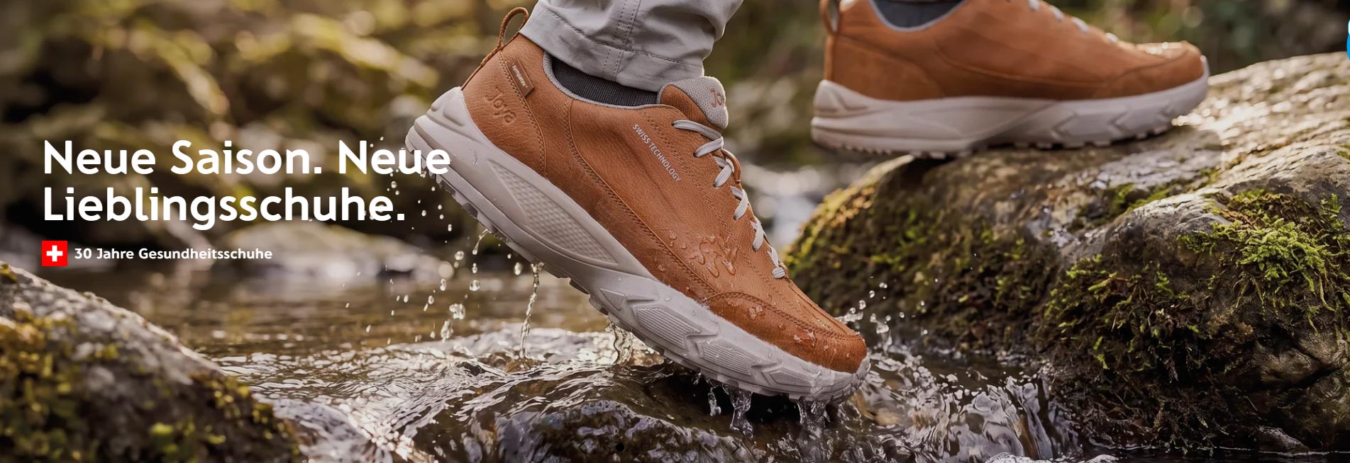 Braune Joya Gesundheitsschuhe mit weißer Sohle beim Gehen über nasse Felsen im Bach – bequeme, wasserdichte Outdoor-Komfortschuhe