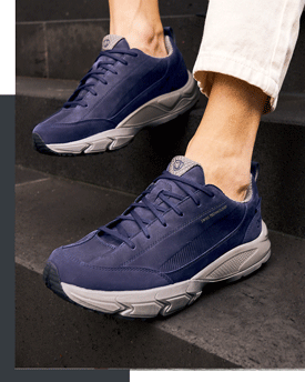 Herren tragen dunkelblaue Sneaker mit grauer Profilsohle auf einer Treppe – sportliche Freizeitschuhe im Produktbild