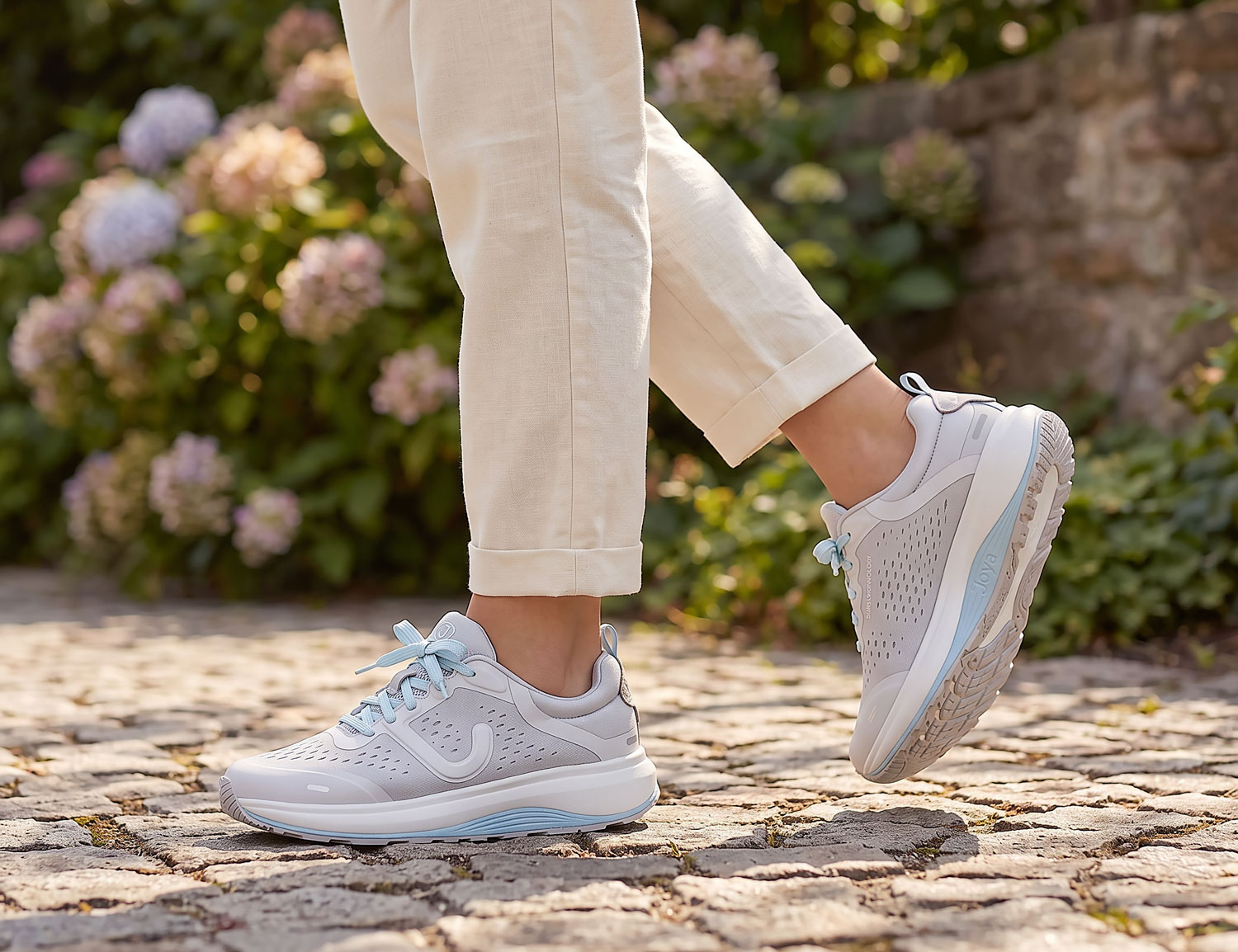 Frau trägt JOYA MIAMI light grey Damen-Schnürschuhe in Hellgrau auf Kopfsteinpflaster – bequemer Freizeitschuh mit weitem Tragegefühl und hohem Laufkomfort