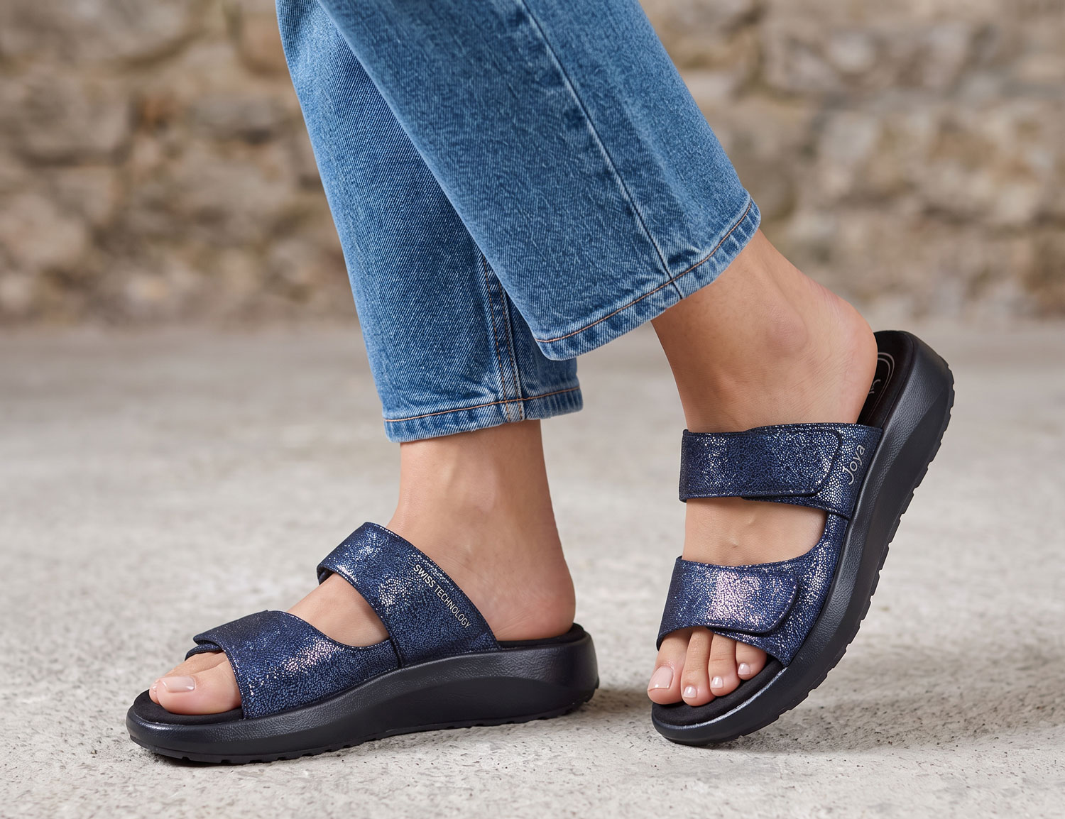 Frau trägt JOYA Vienna III dark blue Damen-Pantolette in Dunkelblau mit breiten Klettriemen und bequemer Komfortsohle