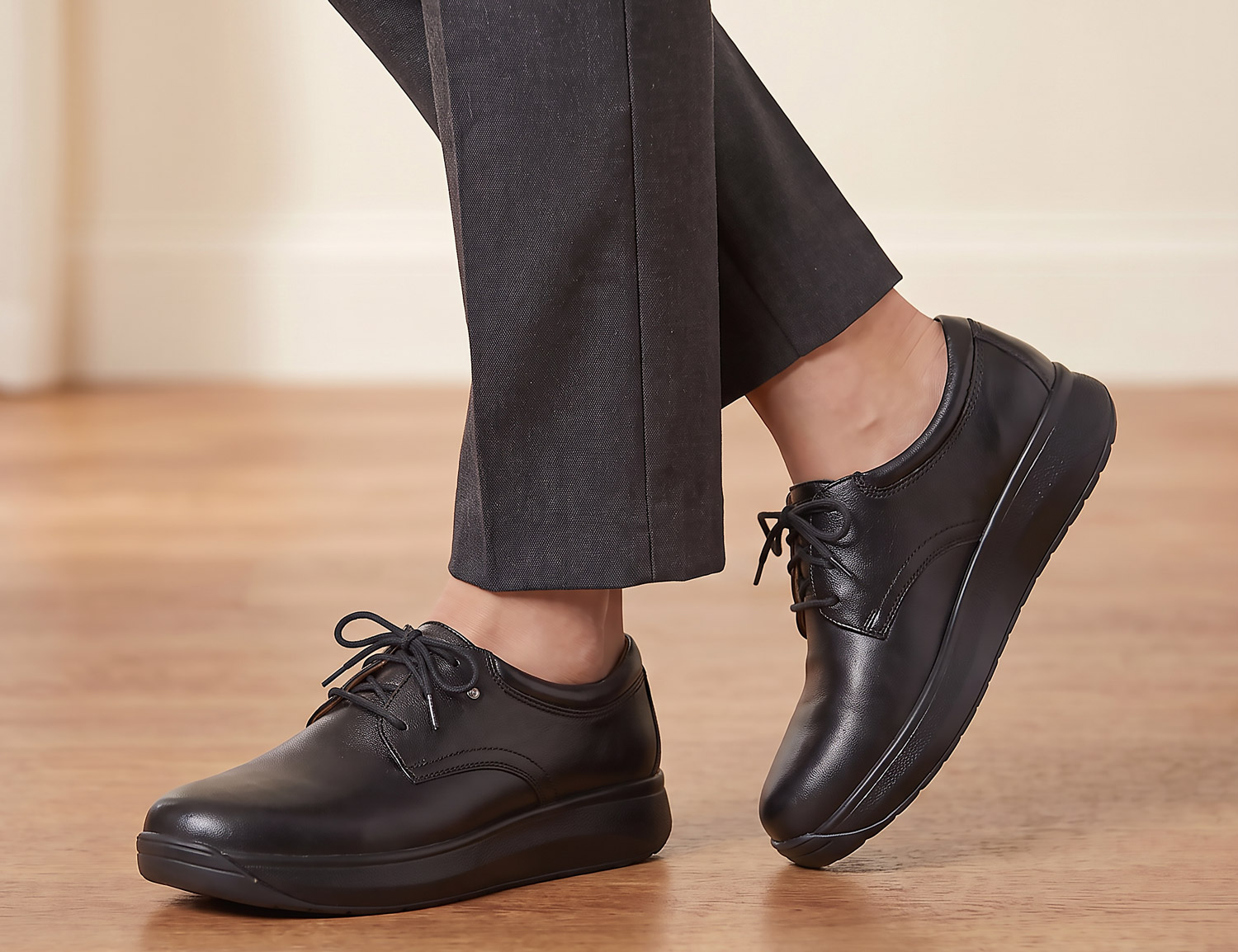 Frau trägt JOYA Emily black, einen schwarzen Komfort-Slipper aus Glattleder mit Schnürung und dämpfender Sohle, elegant und bequem für den Alltag